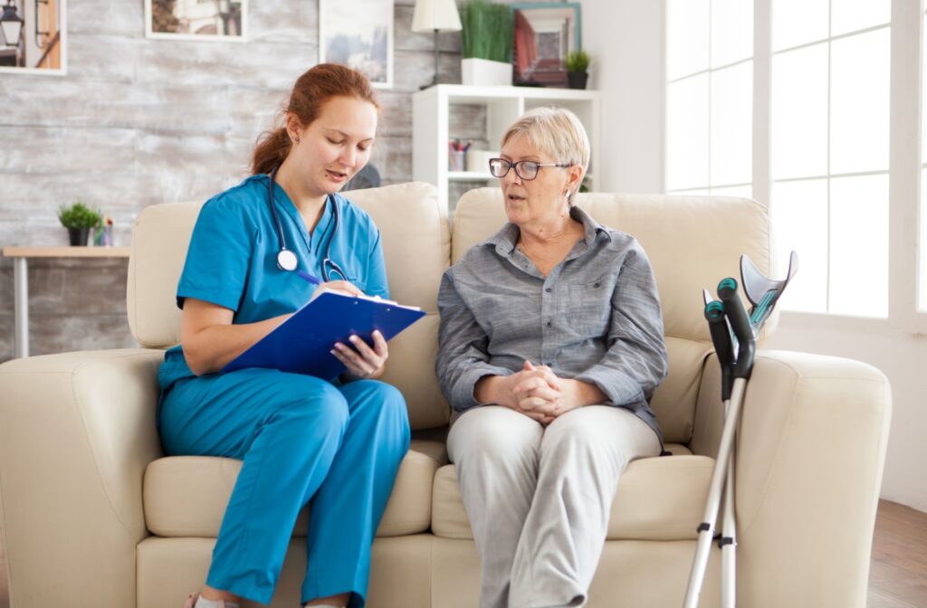 A caregiver assists an older adult in creating a nursing care plan before they move into a senior living community.