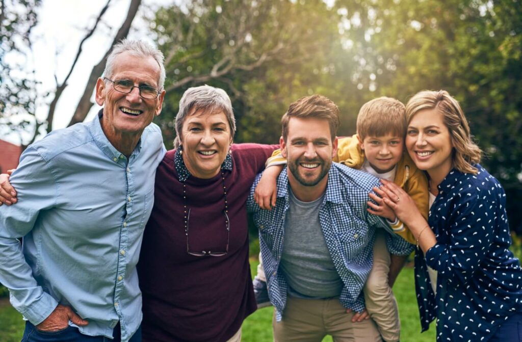 Seniors are in the park with their family, socializing as part of their care plan.